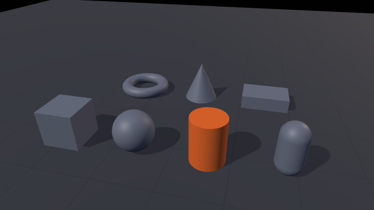 Seven grey shapes — a box, a sphere, a cylinder, a capsule, a torus, a cone and a slab — standing in two rows on a lit grid floor, with the cylinder at the centre of the frame picked out in orange.